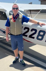 Man wearing Texas Cool Vest standing in front of a plane